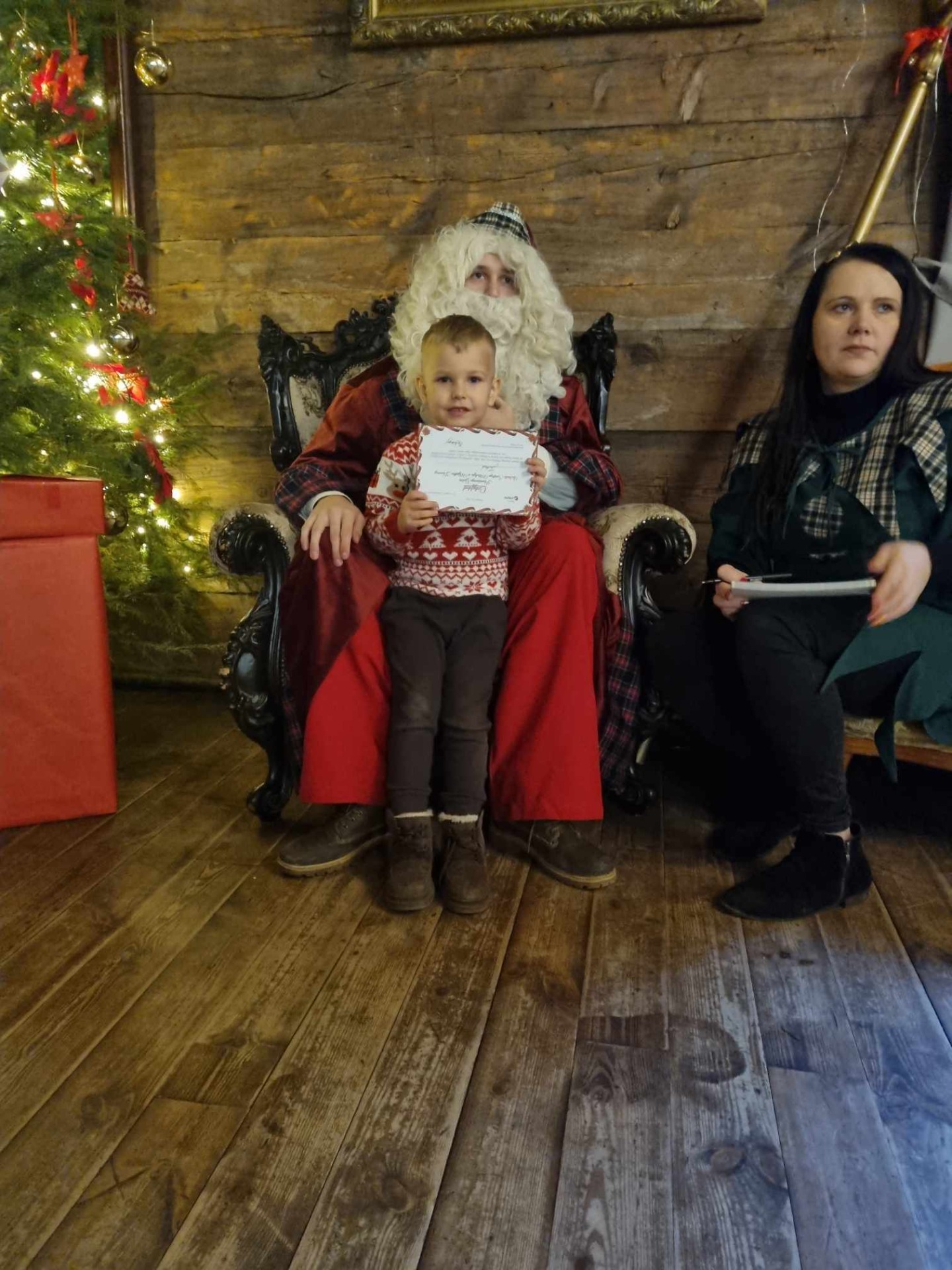 Dziecko obok Świętego Mikołaja i elfa