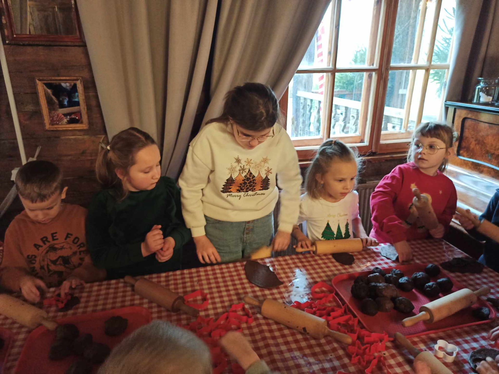 Dzieci siedzą przy stole w chacie Świętego Mikołaja