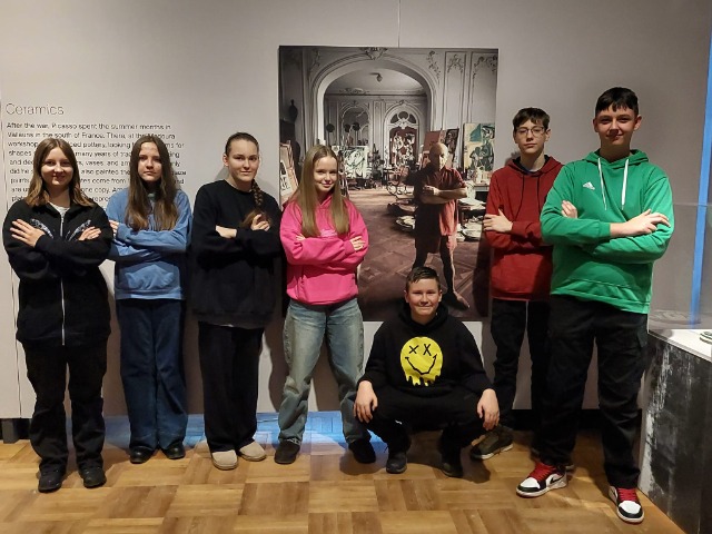 7 uczniów stoi przy plakacie z wizerunkiem Pabla Picassa