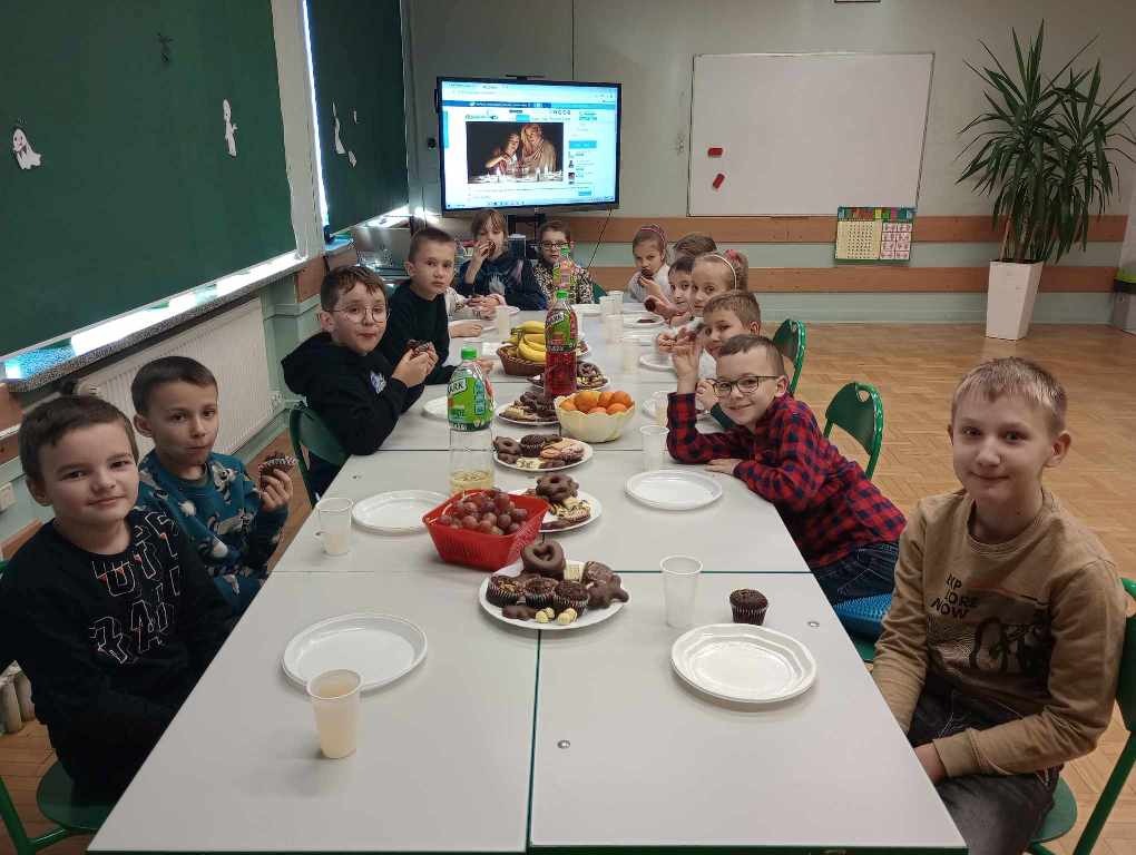 7 dziewczynek i 7 chłopców z klasy 3a przy stole obfitości przygotowanym przez rodziców.

