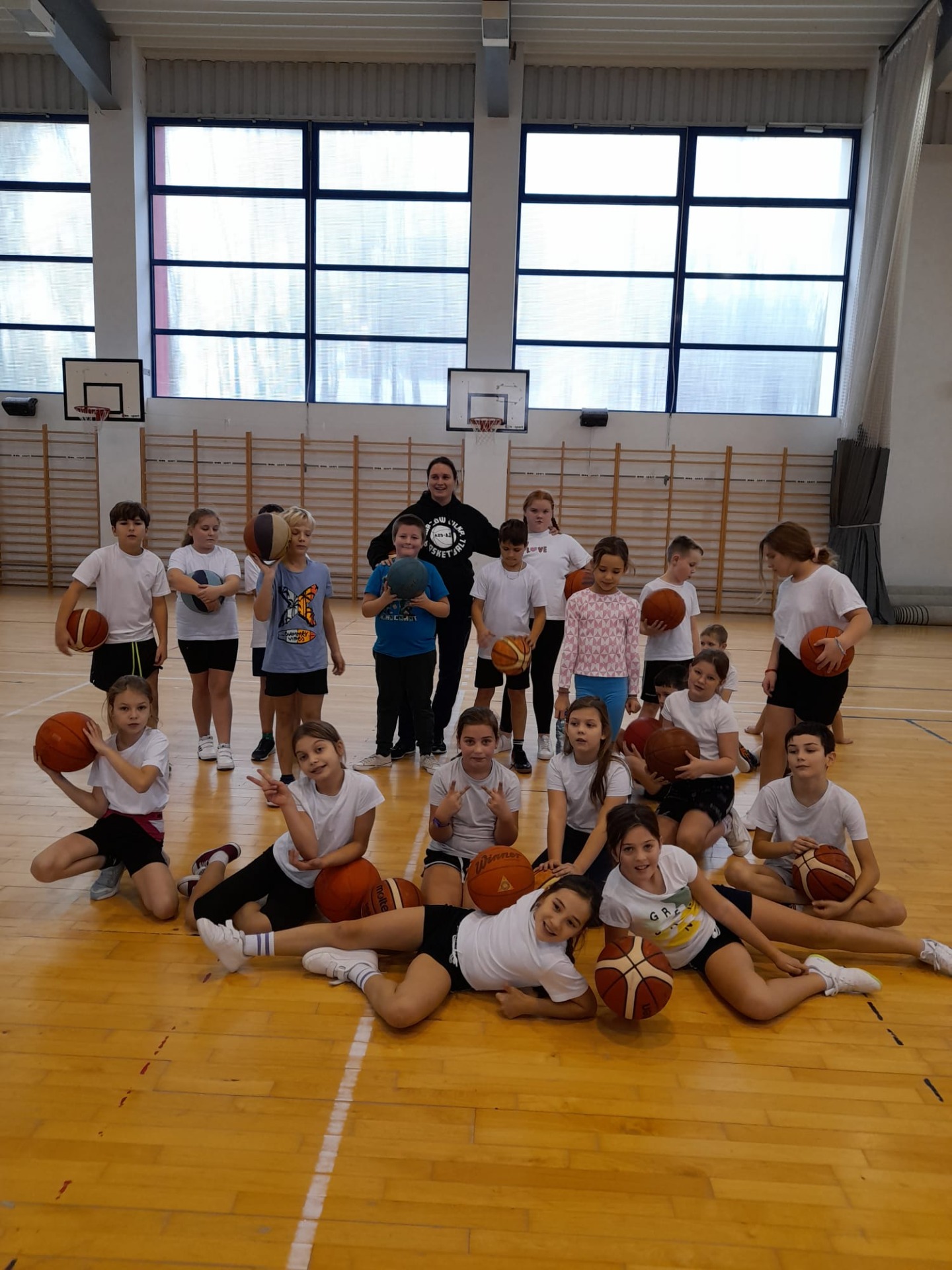 Grupa uczniów z trenerem koszykówki