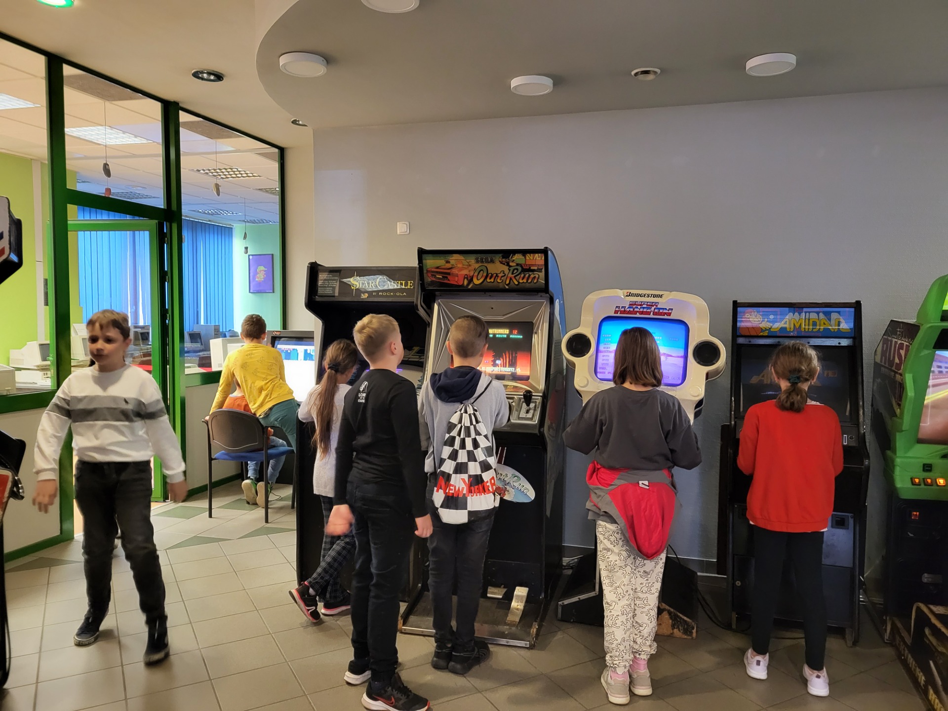 Uczniowie grający na automatach w muzeum komputerów